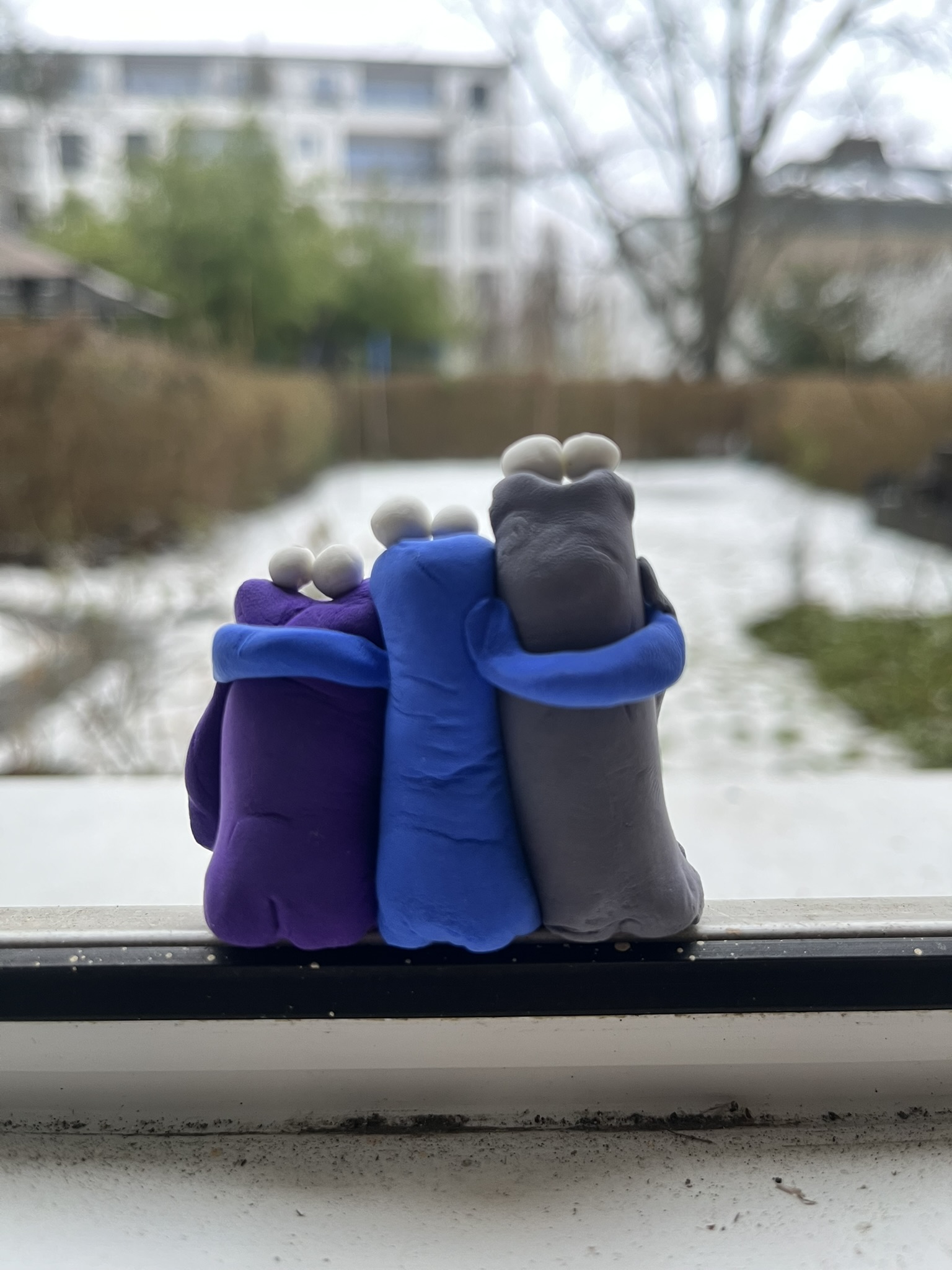 Drei Squigs Arm in Arm schauen aus dem Fenster